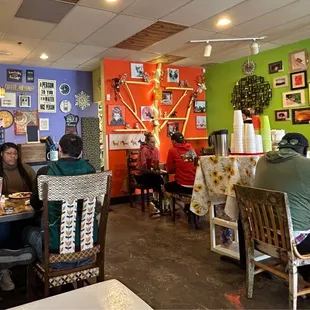 people sitting at tables in a brightly colored restaurant