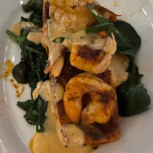 Salmon with shrimp and sauce over spinach