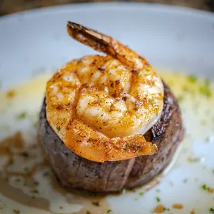 a steak topped with shrimp
