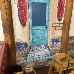 a table and chairs in front of a painted door