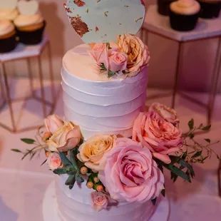 2 tiered wedding cake with cupcakes.