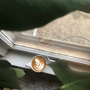 a cup of coffee on a window sill