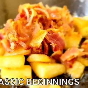 a close up of a frying pan filled with potatoes and bacon