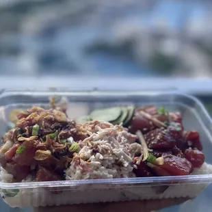 a hand holding a container of food