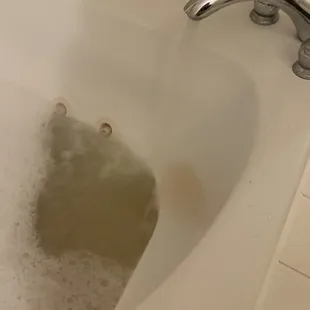 Rusty water going into the dirty tub.