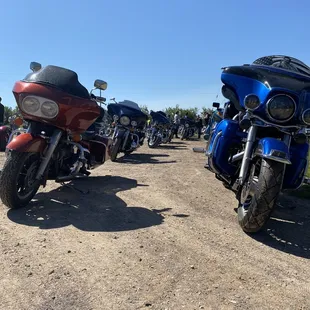 a row of motorcycles parked on a dirt road
