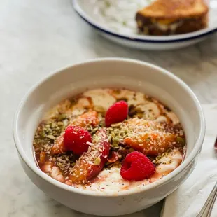 Yogurt bowl with poached peaches, 1/2 grilled cheese in the back