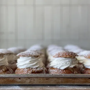 a tray of doughnuts with cream filling