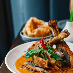 Panang Ped Yang, roasted duck crispy skin with soft and juice meat on top of Panang curry accompanied with flatbread.