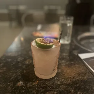 a drink with a lime garnish