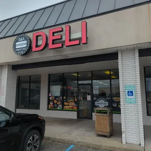 a car parked in front of a deli