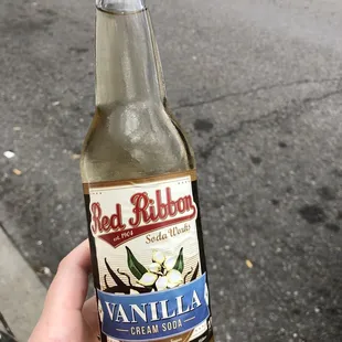 a hand holding a bottle of vanilla