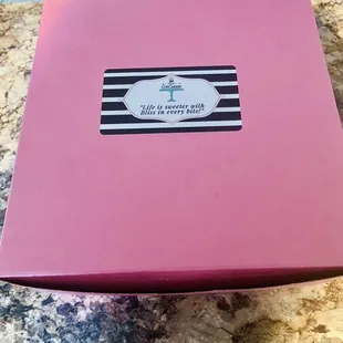 ows a cupcake in a pink box