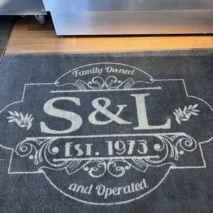 a door mat with the word s &amp; l on it