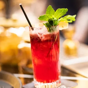 a cocktail with a mint leaf garnish