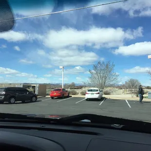 a man walking a dog in a parking lot
