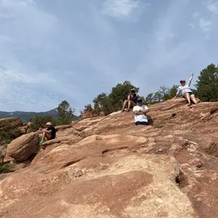  a group of people sitting on a rock