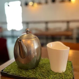 a teapot and a cup on a tray