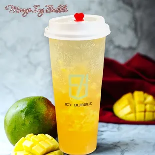 a glass of iced drink with a straw and a mango on the side