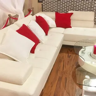 a white couch with red pillows