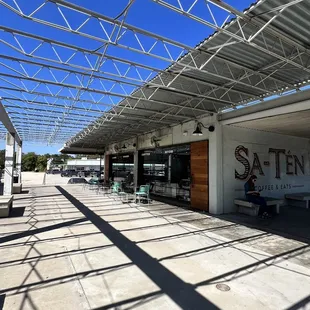 a person sitting on a bench under a roof