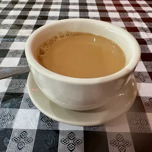 a cup of coffee on a checkered tablecloth