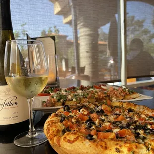 Light Greek pizza with a glass of Chardonnay.