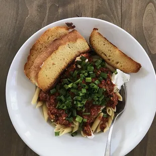 Penne with Bolognese sauce, topped off with green onions and plain yogurt.