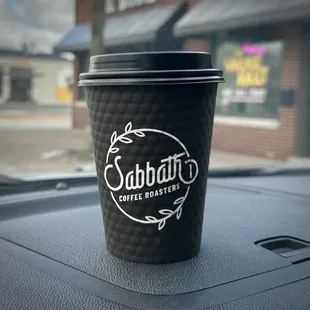 a coffee cup on the dashboard of a car