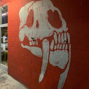 a skull painted on a brick wall