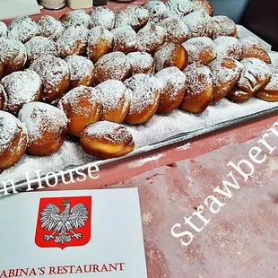 a tray of powdered sugared doughnuts
