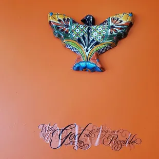 a bird on an orange wall