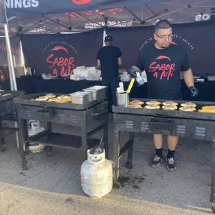 a man preparing food under a tent