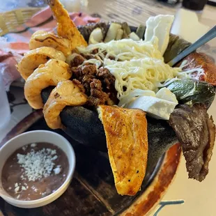 Molcajete...shrimp, beef, chicken, and chorizo..Oaxaca cheese, nopales, onion &amp; chile with a small side of been.