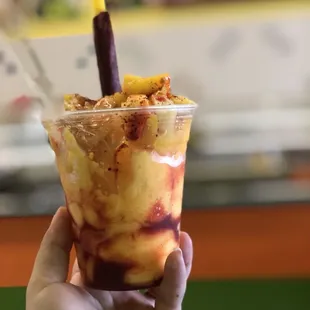 a hand holding a cup of ice cream