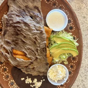 Mexican cheese enchiladas with Cecina meat, black beans, avocado, lettuce and Mexican cream