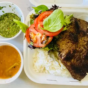 Skirt steak with chimichurri and a side of salad, white rice and beans