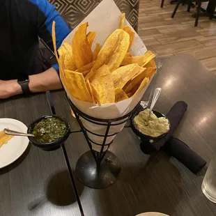 a man sitting at a table with chips and salsa