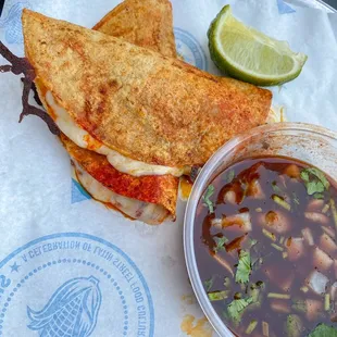 a grilled sandwich with a side of salsa