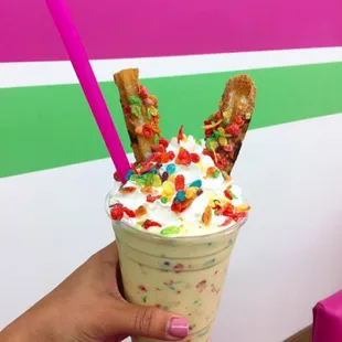 a hand holding a cup of milkshake