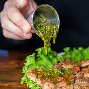 a plate of food being drizzled with sauce