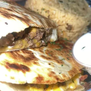 Steak and cheese quesadilla with side of yellow rice.