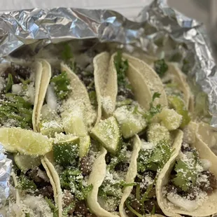 Steak tacos comes with cilantro and onions on soft corn tortilla.