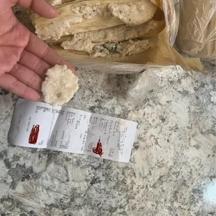 a hand holding a tamales