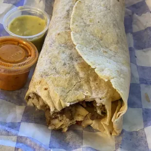 Steak burrito, beans, rice, pico de gallo, sour cream, lettuce, green hot sauce and red hot sauce on side.  The steak is very savory
