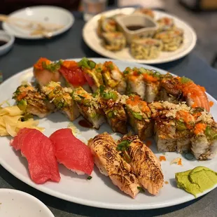 a plate of sushi and other food items