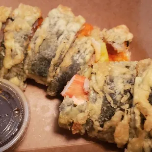 a box of sushi and a container of sauce