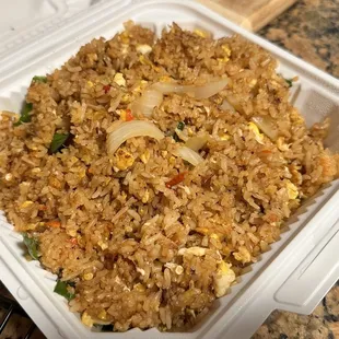a close up of a rice dish in a styrofoam container