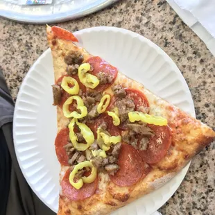 a slice of pizza on a paper plate