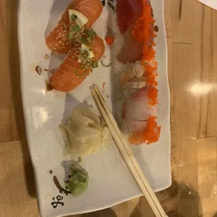 a plate of sushi and chopsticks